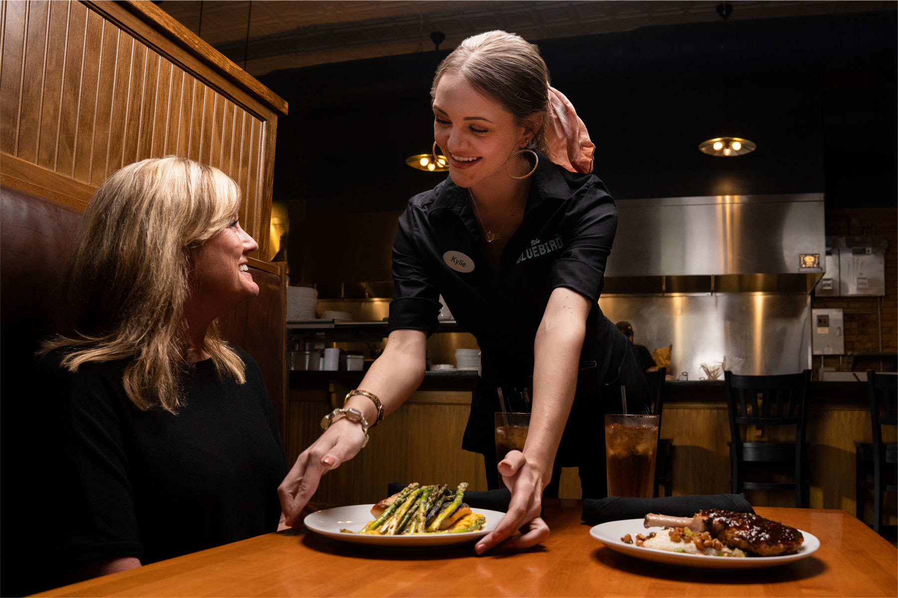 Server delivers food to a female diner at Bluebird. Digital Marketing, Website Design, Branding, Graphic Design, Logo Design, Advertising, and Marketing Agency services in Danville, Kentucky.