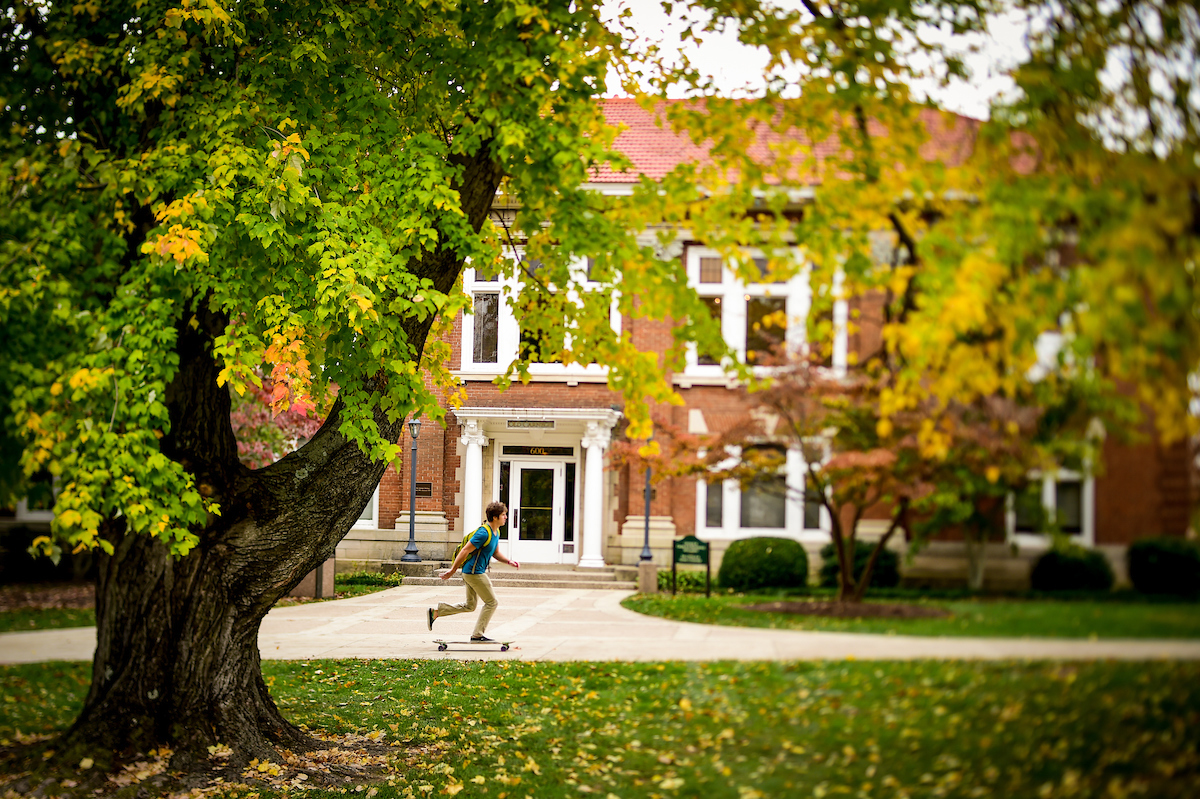 Student skateboarding across campus at Centre College