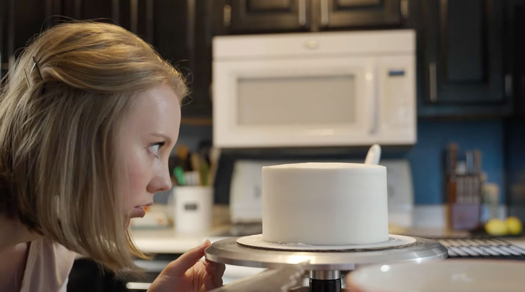 Carrie Irwin works to ice a cake she baked